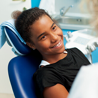 Smiling young woman in state of the art safe orthodontic office