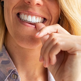 Woman putting on Invisalign in Dayville