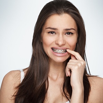 a patient pointing toward her braces