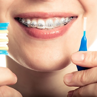 a patient with braces holding a toothbrush