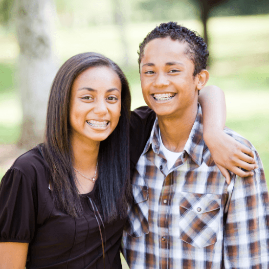 Smiling teen boy and girl with orthodontics