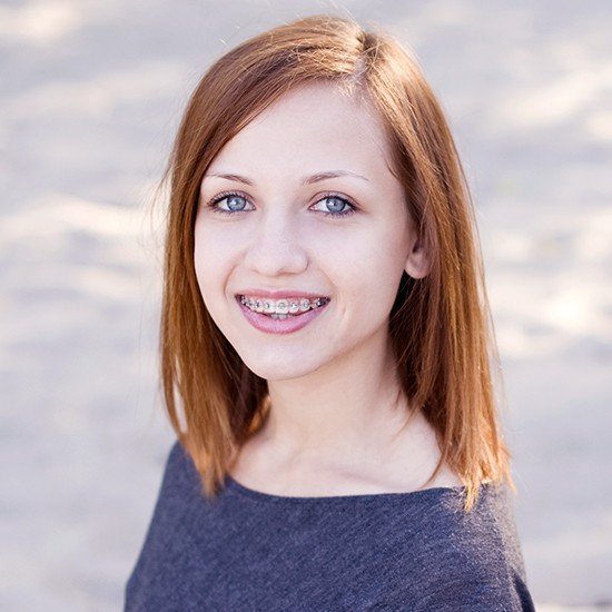 Young woman with traditional braces smiling