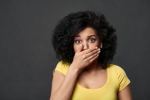 Woman hides her crooked teeth after neglecting wearing her retainer