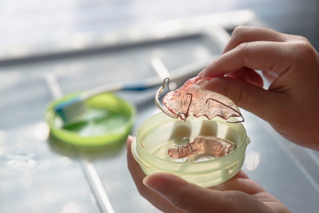 Patient taking dental retainer out of storage case