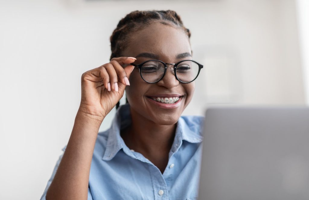 Woman with braces and glasses smiling