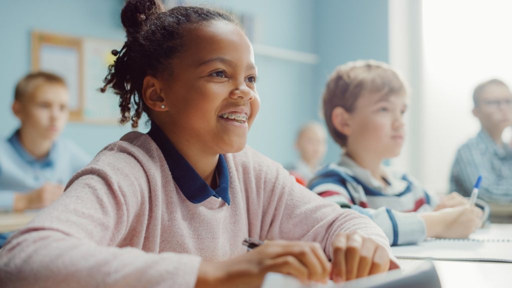 Young girl with braces smiling in classroom