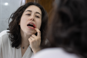 a person inspecting their teeth in a mirror 