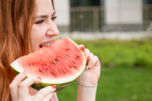 a patient with braces eating a watermelon